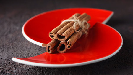 Cinnamon sticks and anise stars on a red split plate