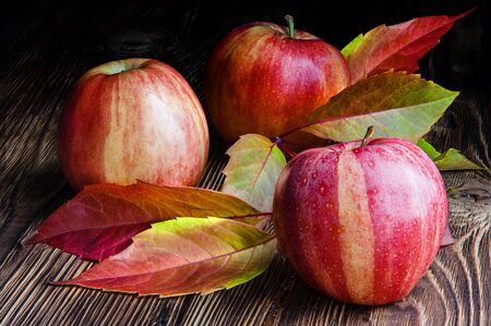 Red striped apples on a wooden tableの写真素材
