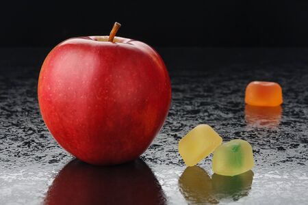 Red apple and marmalade on a black backgroundの写真素材