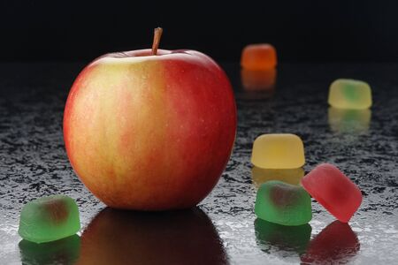 Red apple and marmalade on a black backgroundの写真素材