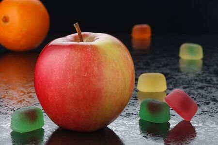 Red apple and marmalade on a black backgroundの写真素材