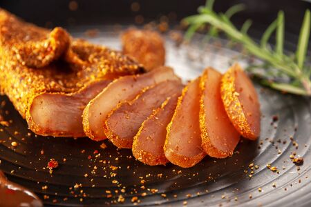 Chicken basturma with hot sauce on a black plateの写真素材