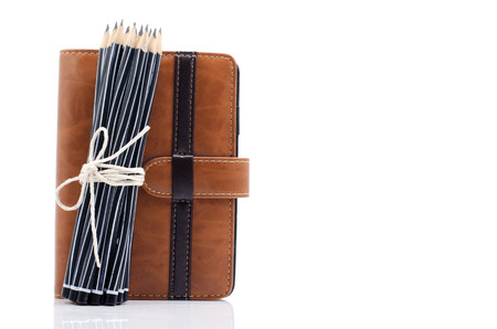 A bunch of pencils and diary isolated on whiteの写真素材