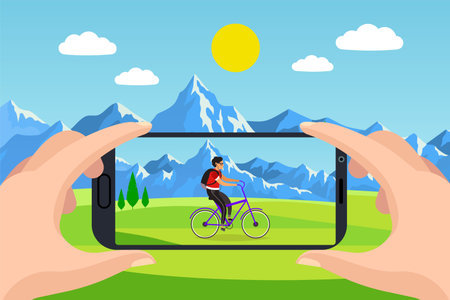 Photo on your phone. Hands hold smartphone, man ride on bicycle on grass and mountains background on...