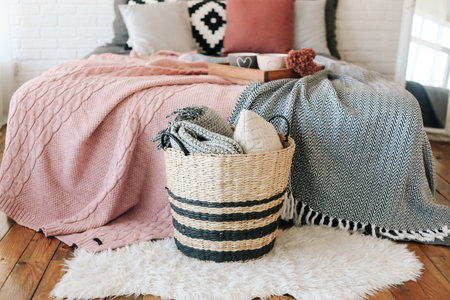bedroom in the interior, a basket with blankets stands near the bed on a carpet of fur