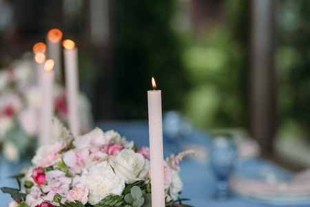 wedding decor on the table with cutlery and flowers and candles with fireの写真素材