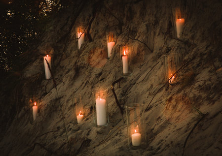 candles in glass vases in the evening on a sandy ravine romantic decorの写真素材