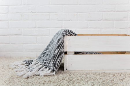 White wooden box with plaid on white brick backgroundの写真素材