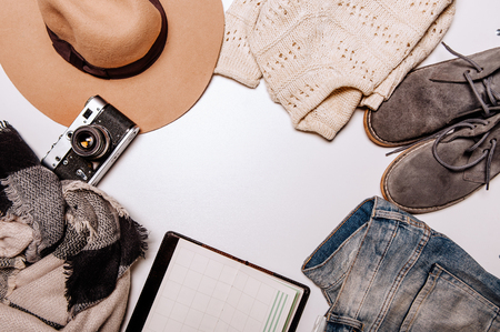 Travel accessories costumes.Â Hat, camera, sweater, jeans, phone, notebook, shoes lie on the white backgroundの写真素材