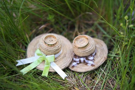 wedding rings lie on small decorated straw hatsの写真素材