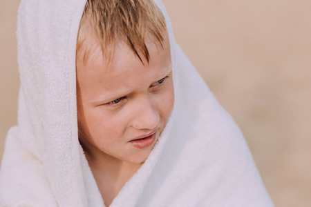 little boy wrapped in a white towel after bathingの写真素材