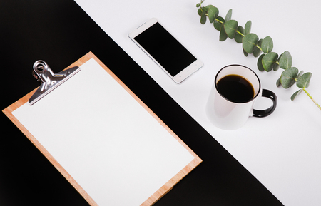 business set with notebook blank page phone cup of coffee empty cards on black and white backgroundの写真素材