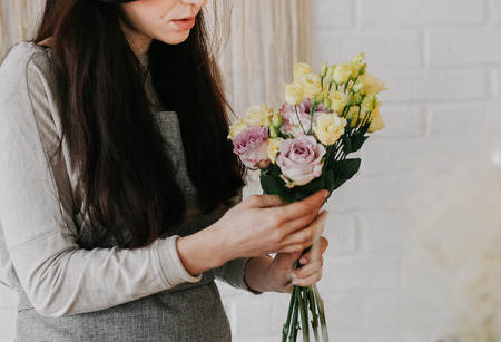 woman florist collects a bouquet roseの写真素材