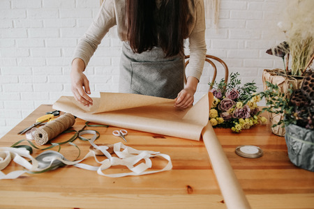 woman florist collects a bouquet decorates from different flowersの写真素材