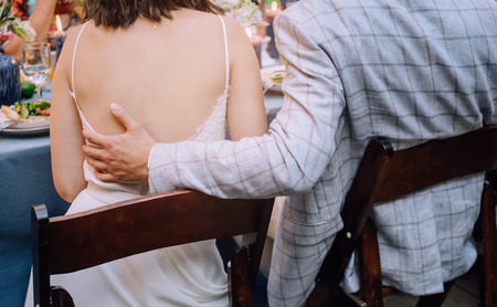 young couple sitting at the table with food and guestsの写真素材