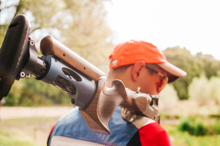 figured butt of a shotgun for sports shooting on the shoulder of a sniper athleteの写真素材