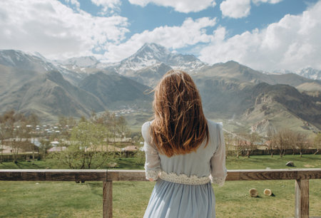 bride in a dress waiting for the groom looking at the mountains with snow peaks