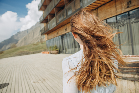 girl in a dress one near a hotel in the hills looking at the mountainsの写真素材