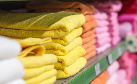 cotton terry colored towels on the shelves in the marketの写真素材