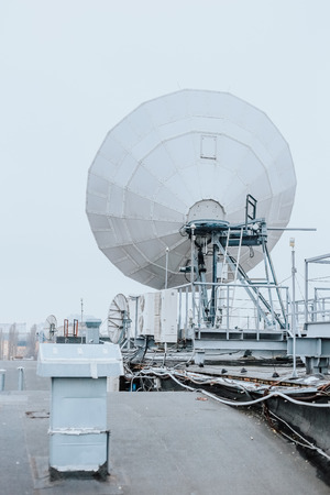 satellite dish industrial on the roof of the buildingの写真素材