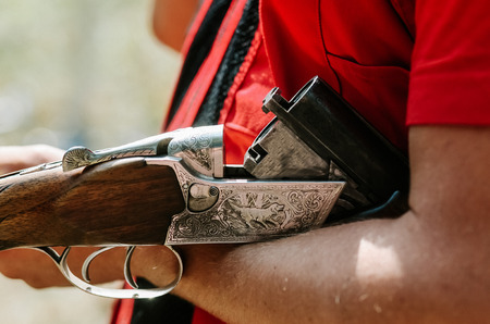 man hunter holds an uncharged shotgun on his hand close with a hunting patternの写真素材