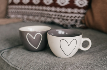 Two cups with hearts for loving couples in the home interiorの写真素材