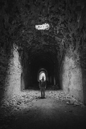 tourist man near the ruins of an old military fort with beautiful architecture large arch walls and...