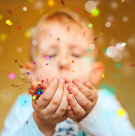 one kid on the background of a Christmas tree of garlands and a shiny glitter
