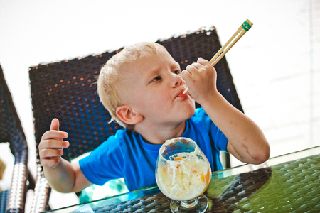 boy drinking milk cocktail with a straw in a cafeの写真素材