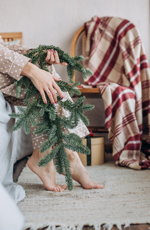 girl in a beige nightgown pajamas opens gifts boxes with ribbons for the new yearの写真素材