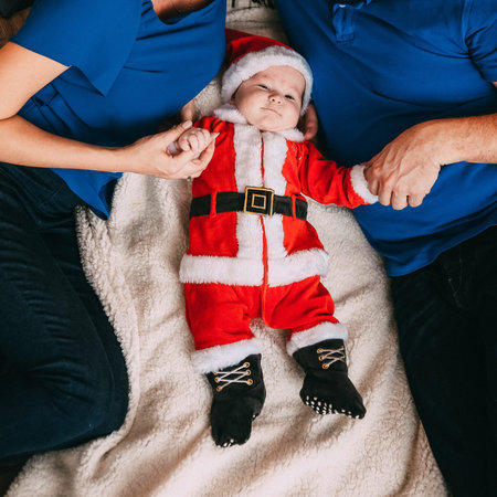 parents with baby for the holiday new year in santa suit