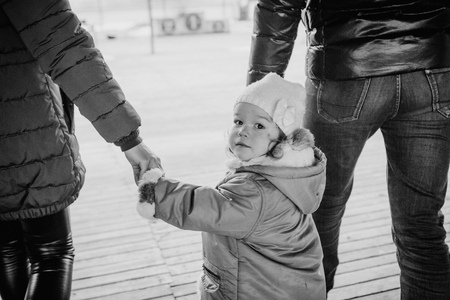 lovers go by the hand with a small child outside in jacketsの写真素材