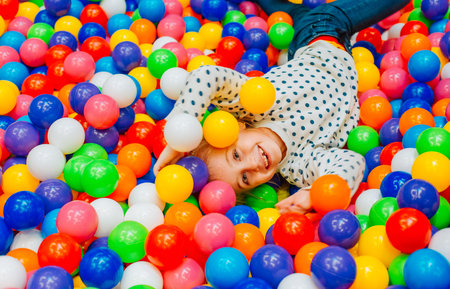 boy jumps in colorful balls activity joy and laughter
