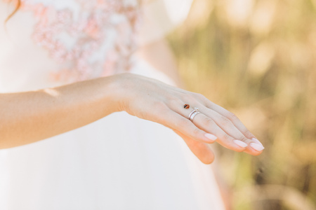 hands of the girl bride in a white dress ring tenderness flowersの写真素材