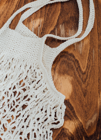 white eco bag mesh texture on a natural wooden branch beige backgroundの写真素材
