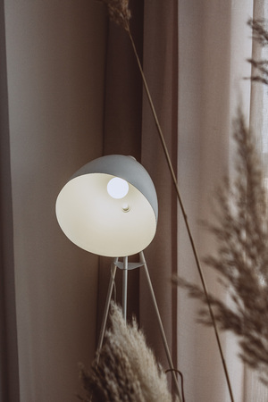 interior of a cozy bedroom in the loft style with a lamp and textiles curtainの写真素材