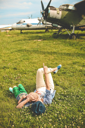 mother hugging baby near airplane outside season summerの写真素材