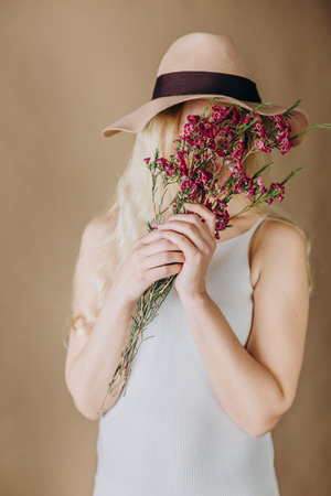 woman blonde in a gray dress with flowers and hat brownの写真素材