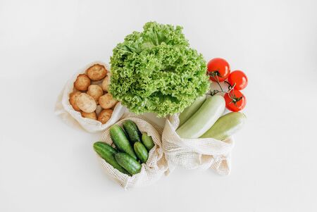 set of products in eco mesh bag tomato zucchini cucumber potatoes greens saladの写真素材
