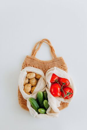 set of products in eco mesh bag tomato cucumber potatoesの写真素材