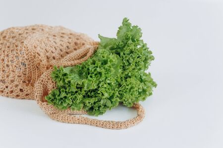 vegetables greens salad in eco mesh beige bag washed clean mock upの写真素材