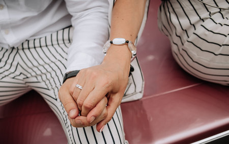 couple in love sit on the hood of a retro car and hold hands summer