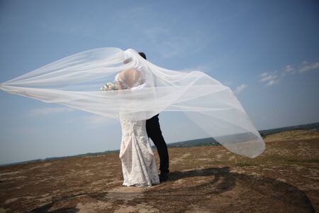 wedding bride and groom on top of a wind veilの写真素材
