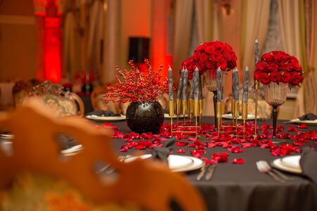 interior festive table evening dinner by candlelight with red lightingの写真素材