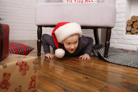 children playing hide and seek in christmas decorations inside with santa hat