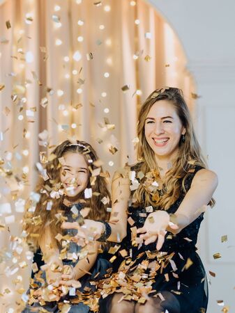 family mother with daughter joyful emotions celebrate new year with metaphane and lights of garlandsの写真素材