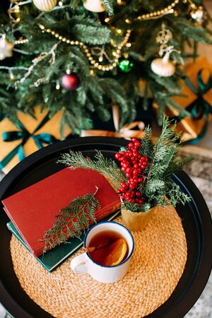 steam over a cup of hot tea with lemon and cinnamon christmas decor and elegant tree in bokehの写真素材