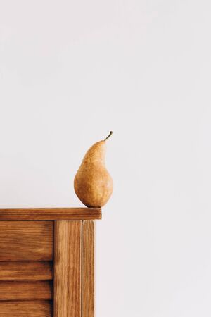 one big ripe pear on the edge of the table on a white backgroundの写真素材