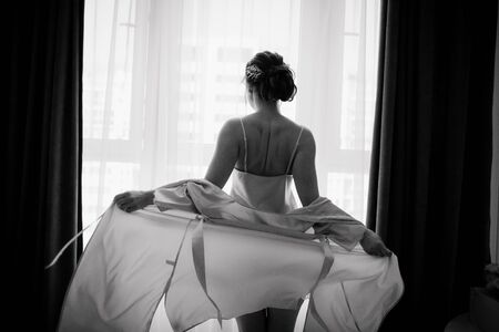 girl intimate atmosphere inside bedroom underwear bathrobe beautiful body backsideの写真素材