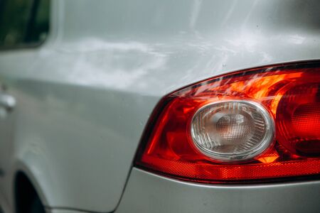 red taillight of a gray car with drops of water after washingの写真素材